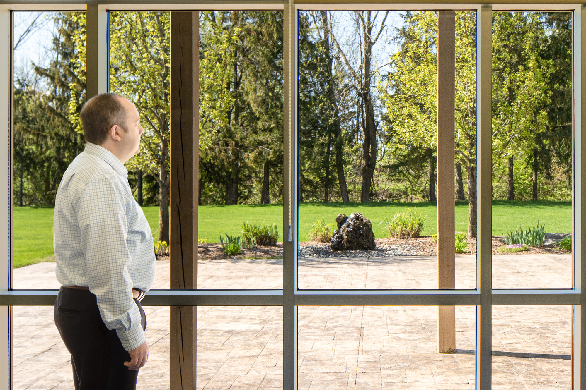 Man looking out the windows of Kent and Essex office