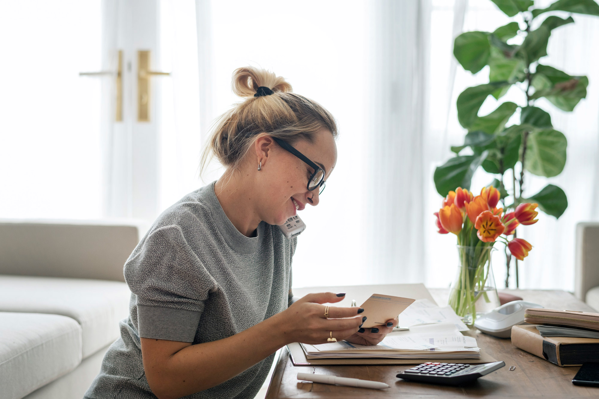 Girl on the phone while doing calculations on calculator