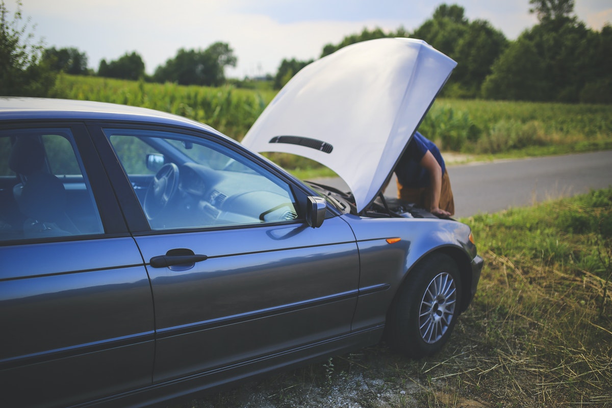 Person looking under the hood of their car