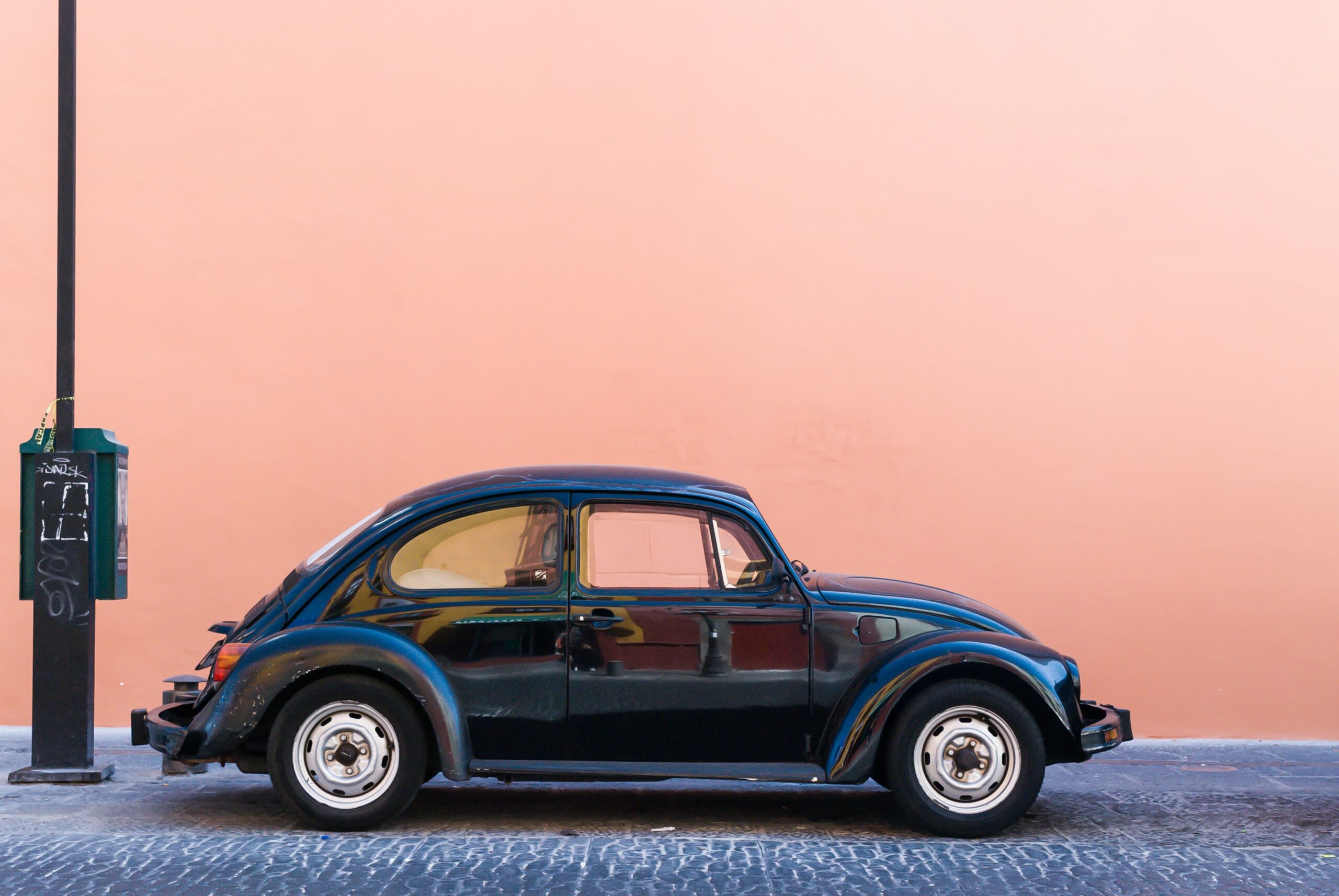 Volkswagon beatle against a pink wall background